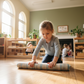 A child rolling up a small carpet